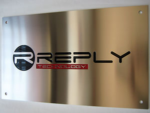 Targa aziendale in acciaio spazzolato con logo inciso e smaltato a 2 colori con quattro fori per il fissaggio al muro