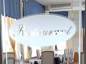 Decoro con vetrofania effetto vetro sabbiato su porta ingresso ristorante di un hotel