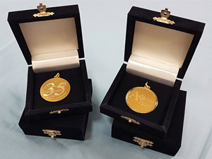 Medaglie in oro con logo e dedica. Incise a punta di diamante e complete di astucci in velluto blu