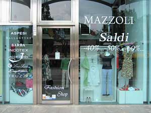 Scritte adesive per vetrine. Allestimento vetrina con loghi firme ditte per vendita promozionale in un negozio di abbigliamento