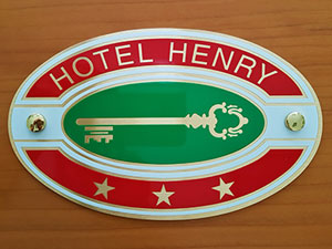 targa ovale per hotel in ottone satinato con grafica stampata e protetta con vernice trasparente per esterno