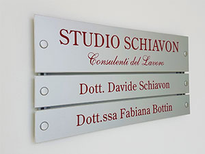 targhe intercambiabili per studio commercialistico in alluminio preverniciato color argento con scritte nomi stampati fissate al muro su binari in alluminio