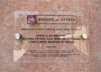 targa in plexiglass trasparente con logo e testi stampati applicata al muro con distanziatori in acciaio